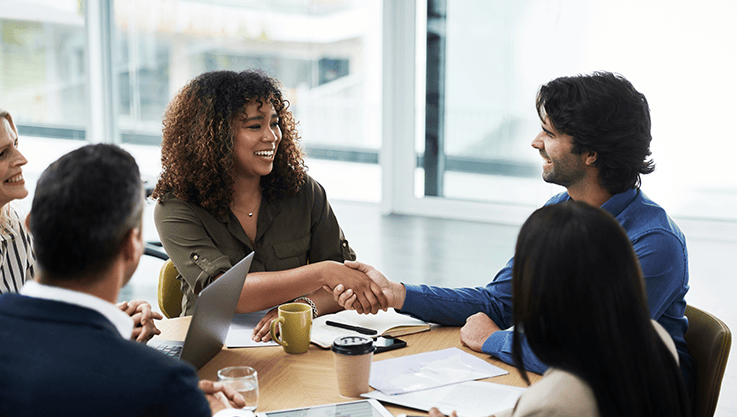 In a bright office, 4 people meet for a business meeting